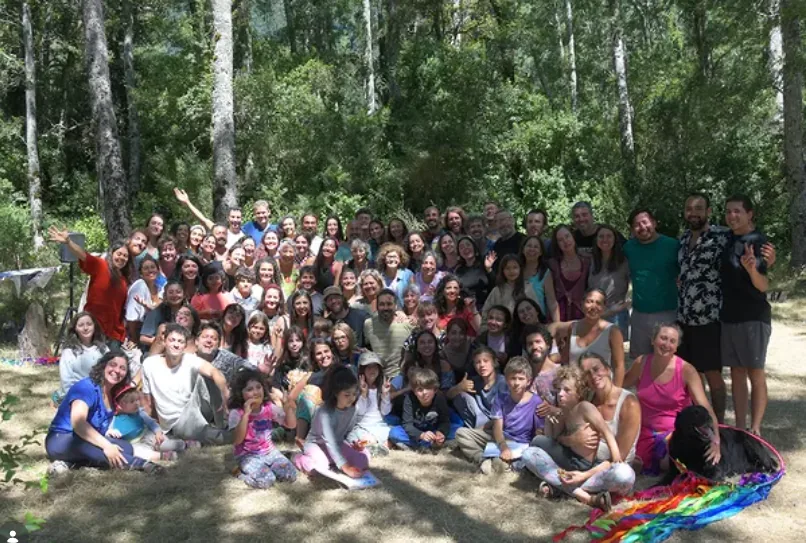 Todo el grupo, con niñas y niños, reunido en el bosque