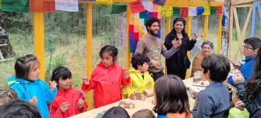Niñas y niños en un taller bajo las banderas de colores